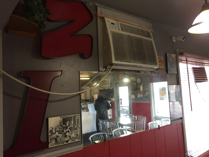 Wall with Vintage Photos, Old Sign Lettering, Mirror, Air Conditioner, and Window at Pasquale's, 3623 West 16th Street, Indianapolis